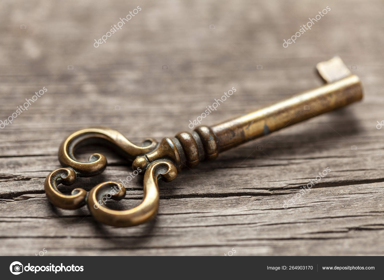 Old copper key on wooden table Stock Photo by ©ADragan 264903170