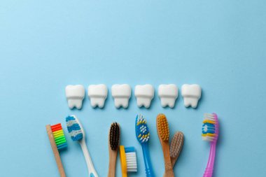 Diş fırçası ile mavi arka planda sağlıklı beyaz dişler. Metin için boşluk Kopyala.