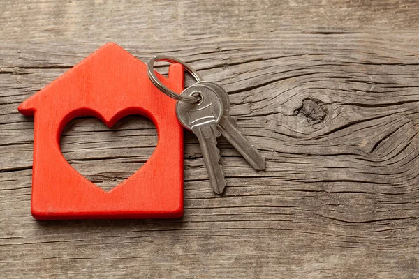 Casa in legno rosso e le chiavi sulle vecchie tavole di legno. Copia spazio per testo . — Foto Stock