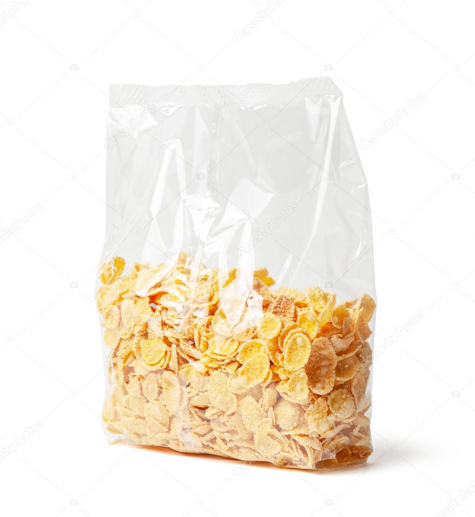 Cornflakes dry breakfast. Yellow flakes in a transparent plastic packaging isolated on white background