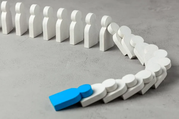 Domino effect in business. One businessman leader falls and brings down other figures of employees. System disruption.