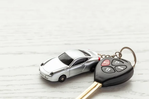 白い木製の背景にリモート コントロール セキュリティ、車キー チェーン付きの車の鍵。コピーのテキストのための領域 — ストック写真