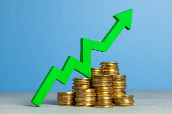 Стрелка вверх и стопка монет. Концепция повышения налогов или увеличения прибыли в бизнесе
