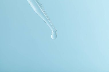 Pipet damlası. Biyolojik materyalin incelenmesi. Laboratuvar araştırmaları. Mavi arka plan