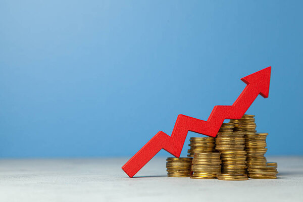 Стрелка вверх и стопка монет. Концепция повышения налогов или увеличения прибыли в бизнесе
