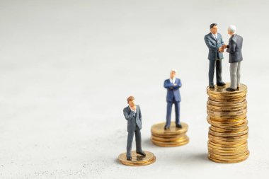 İşadamları, başarılı kârlı bir işlemin sembolü olarak el sıkışıyor. Başarılı ya da başarılı yatırımların sembolü olarak altın sikke yığını üzerinde Işadamları. Metin için alan kopyalama.