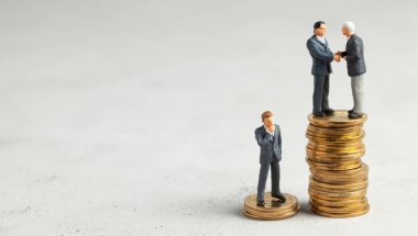 İşadamları, başarılı kârlı bir işlemin sembolü olarak el sıkışıyor. Başarılı ya da başarılı yatırımların sembolü olarak altın sikke yığını üzerinde Işadamları. Metin için alan kopyalama.