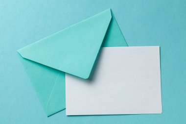 Yeşil zarf ve yeşil arka plan üzerinde boş mektup. Kartpostaldaki metin yerine şablon. Mock