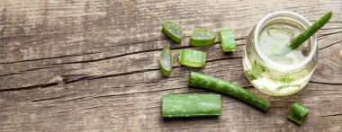 Cilt ve vücut bakımı için Aloe Vera jel kremi. Aloe cam bir kavanozu dilimler ve ahşap bir masada bırakır. Kozmetik losyon.