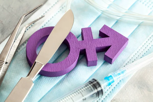 Cinsiyet değiştirme operasyonu. Transseksüel sembolü ve şırıngalı neşter. Cerrahi Araçlar