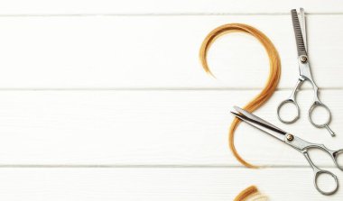 Kıvırcık saçtan yapılmış soru işareti. Saç stili ya da kuaför seçimi yapma fikri. Beyaz ahşap arka plan, saç ve seyreltici makas. Metin için alanı kopyala.