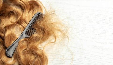 Karışık uzun saç ve siyah tarak. Kıvrımlı bir düğüm. Metin için alanı kopyala.