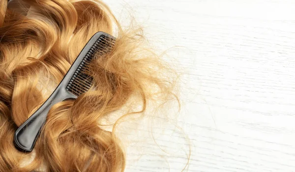 Karışık uzun saç ve siyah tarak. Kıvrımlı bir düğüm. Metin için alanı kopyala.