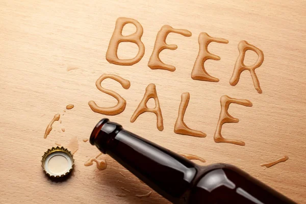 Bier zum Verkauf. Bierflasche und verschüttetes Getränk auf dem Tisch — Stockfoto