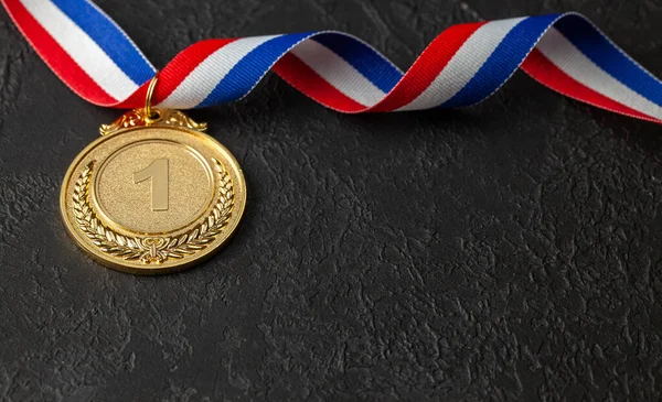 Goldmedaille mit Schleifen. Auszeichnung für den ersten Platz im Wettbewerb. Preis für den Champion. Schwarzer Hintergrund — Stockfoto