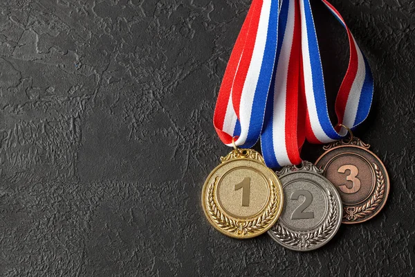 Zlatá, stříbrná a bronzová medaile se stuhami. Ocenění za první, druhé a třetí místo v soutěži. Cena pro šampióna. Černé pozadí — Stock fotografie