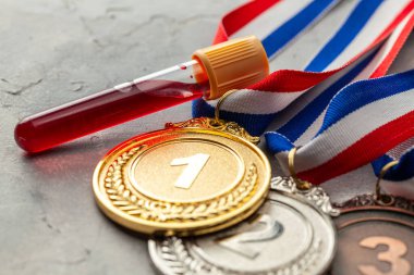 Doping testi. Altın, gümüş ve bronz madalya ve üzerinde kan olan test tüpü