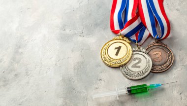 Sporcular için doping. Altın, gümüş ve bronz madalya ve gri arka planda doping şırıngası