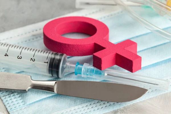 Sex-change operation. Change of female to male. Symbol of a woman and a scalpel with a syringe. Surgical Instruments — Stock Photo, Image