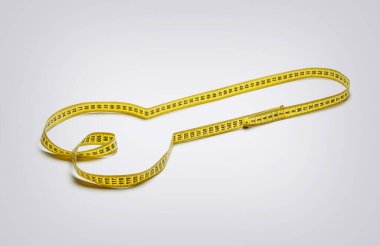 Penis from a yellow measuring tape on a gray background. Measurement of the male genital organ