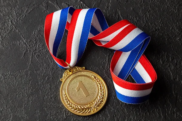 Goldmedaille mit Schleifen. Auszeichnung für den ersten Platz im Wettbewerb. Preis für den Champion. Schwarzer Hintergrund — Stockfoto