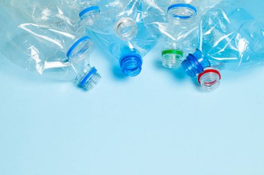 Mavi arka planda buruşmuş plastik şişeler. Plastik çöp. Metin için alanı kopyala.