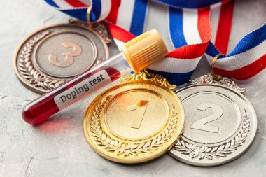 Doping testi. Altın, gümüş ve bronz madalya ve üzerinde kan olan test tüpü