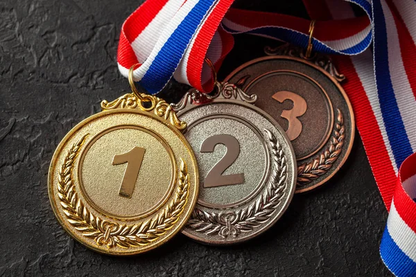 Medalla de oro, plata y bronce con cintas. Premio al primer, segundo y tercer lugar en la competición. Premio al campeón. Fondo negro —  Fotos de Stock