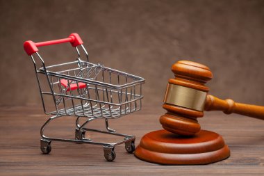 Alışveriş sepeti ve yargıç tokmağı tahtadan kahverengi arka planda