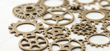 Gri arkaplandaki saatten eski metal dişliler