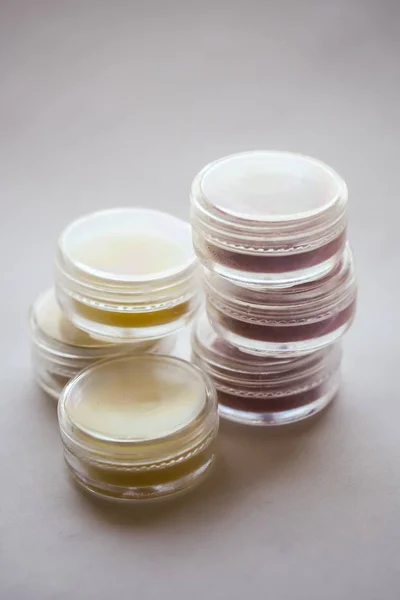 jars with colored cosmetic lip balm on a light background, lip care