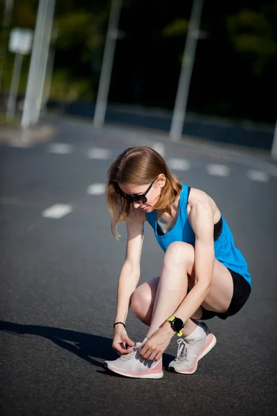 ジョギング前のスポーツウォーミングアップをする短髪の若いアスリート女性 — ストック写真