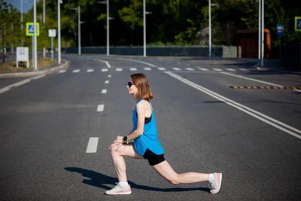 ジョギング前のスポーツウォーミングアップをする短髪の若いアスリート女性 — ストック写真
