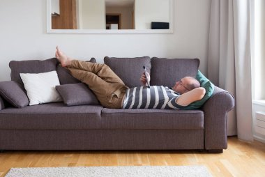 adam yalan kanepede ve dijital tablet kullanma