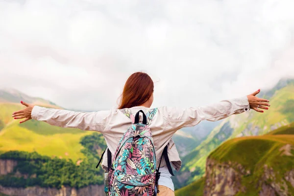 Genç Kızıl saçlı kız kollarını bir arka plan dağ güneş kadar kaldırdı