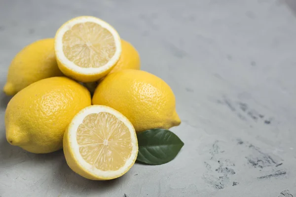 Limones sobre fondo de piedra gris, espacio para copiar. Cítricos frescos ecológicos —  Fotos de Stock