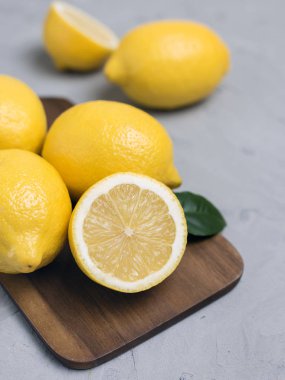 Bütün ve dilimlenmiş limon ahşap kesme tahtası üzerinde. Organik taze narenciye