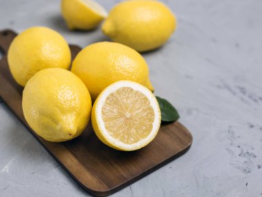 Bütün ve dilimlenmiş limon ahşap kesme tahtası üzerinde. Organik taze narenciye