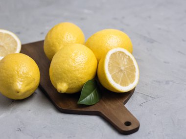 Bütün ve dilimlenmiş limon ahşap kesme tahtası üzerinde. Organik taze narenciye