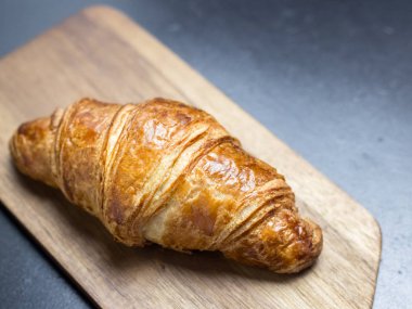 Siyah zemin ahşap tahta üzerinde taze kruvasan