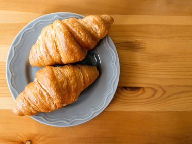 Ahşap bir arka plan üzerinde taze pişmiş kruvasan. Pişirme veya pasta arka plan