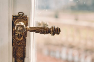 Beyaz ahşap kapı ve çelik el kilidi olan cam. Pencereli eski kapı tokmağı. Mesajlaşmak için bir yer. Eski moda iç mekan. Yakın plan. Parlak arkaplan