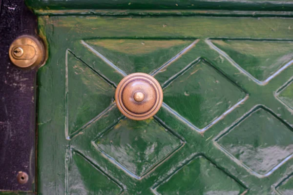 Pomo de puerta antigua en el casco antiguo. Pomo de puerta de latón clásico en estilo vintage puerta verde — Foto de Stock