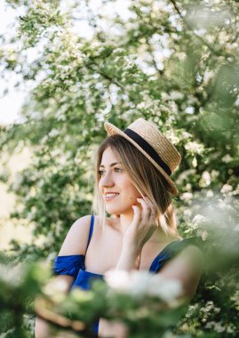 Çiçekli çalılıklarda beyaz spirea çiçekleriyle güzel hippi bir kadının şehvetli sakin portresi..