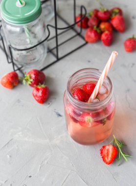 Biberiyeli çilekli limonata ve taş kavanozunda buz gri beton bir masada. Mevsimlik gıda konsepti. Yaz zamanı.