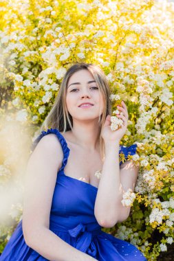 Çiçekli çalılıklarda beyaz spirea çiçekleriyle güzel hippi bir kadının şehvetli sakin portresi..