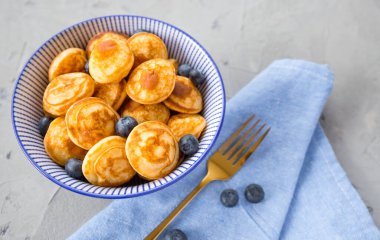 Gri arka planda yaban mersinli mini gevrek krepleri. Moda yemek konsepti, çocuklar için kahvaltı zamanı. Menü