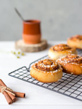 Ahşap arka planda baharatlı taze pişmiş tarçınlı çörekler. Kanelbule - İsveç tatlısı. Yemek konsepti. Kırsal biçim
