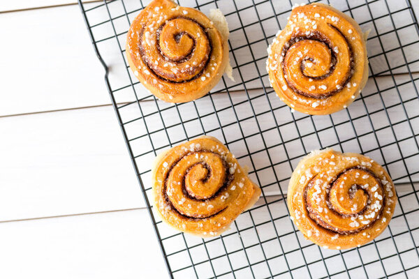 Freshly baked cinnamon buns with spices on a wooden background. Kanelbule - swedish dessert. Food concept. Top view, flat lay