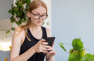 Kafede cep telefonu kullanan, sosyal ağlarda mesajlaşan, serbest çalışan, aktif hayat konsepti olan güzel bir kadın. Yaz yaşam tarzı.